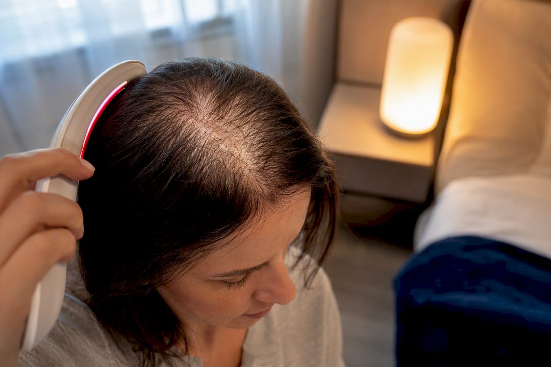 Woman using at-home scalp light therapy