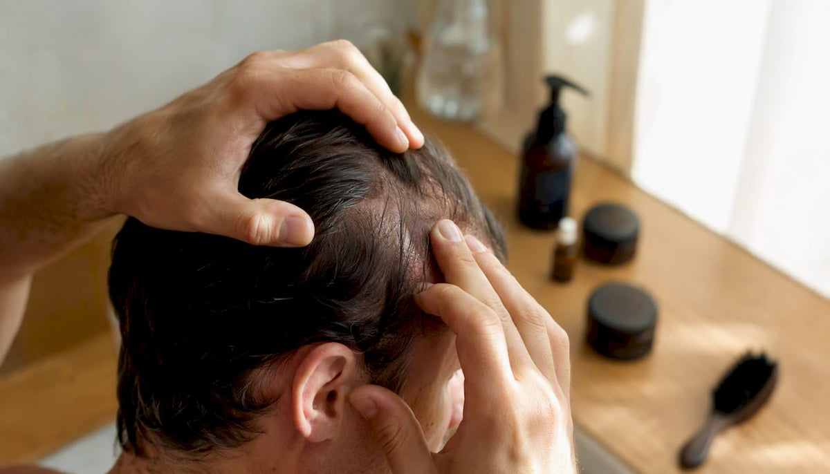 Hands applying leave-in serum to thinning scalp