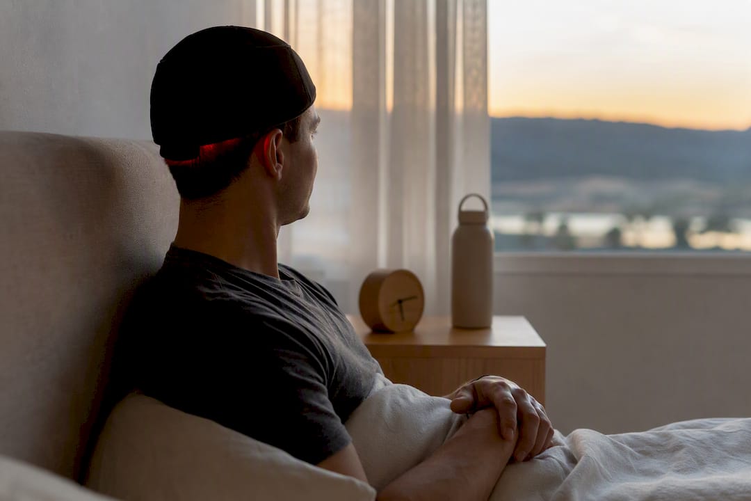 Person wearing red light therapy cap for hair