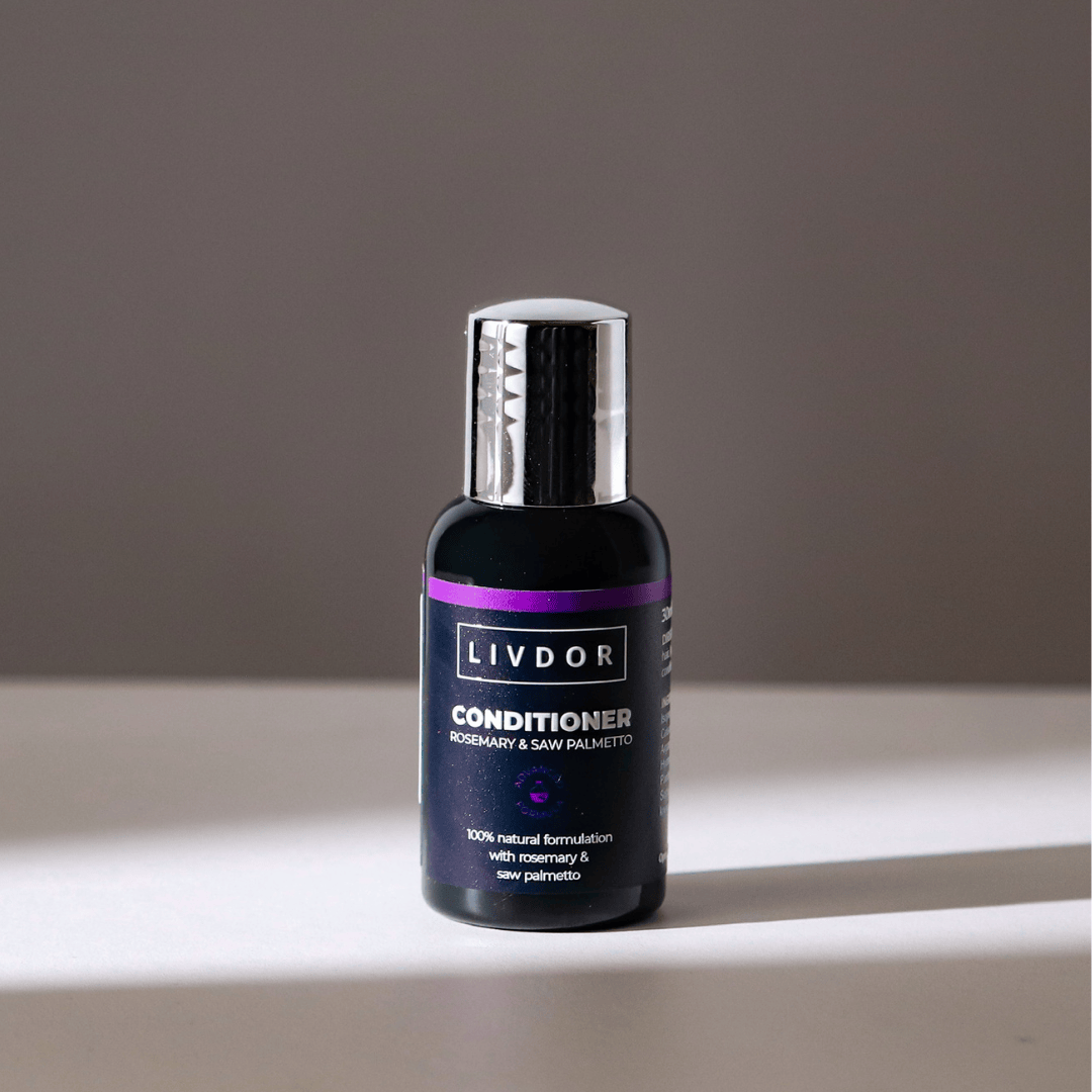 A travel sized bottke of Livdor Conditioner for dry, damaged, and curly hair, featuring a dark purple label with a metallic silver cap, set against a neutral gray background.